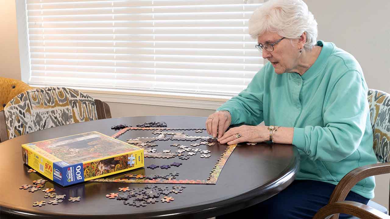Resident putting together a puzzle at Amelia Senior Living