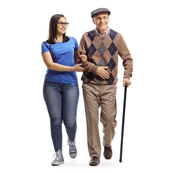 Senior male walking with cane being assisted by a nurse.