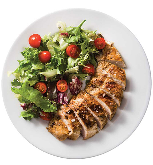 Plate of sliced chicken and a side salad