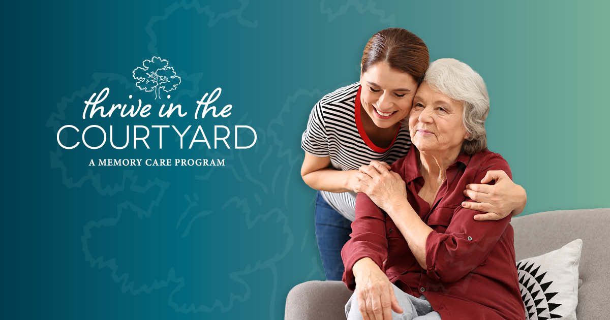 A younger woman hugs and smiles at an older woman seated on a couch. Text reads "Thrive in the Courtyard: A Memory Care Program" on a teal background.