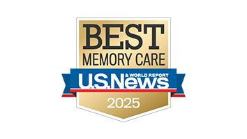 A gold and blue badge reading "Best Memory Care, U.S. News & World Report, 2025" with a gold ribbon at the bottom celebrates excellence in senior living.