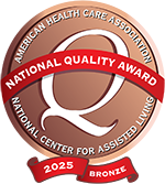 Bronze 2025 National Quality Award emblem from the American Health Care Association/National Center for Assisted Living, featuring a large "Q" and a red ribbon banner.
