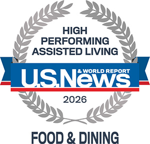 A silver laurel wreath surrounds the words “High Performing Assisted Living” above a blue ribbon with “U.S. News & World Report 2026” and “Food & Dining” written below in bold text.
