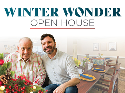 Two men, one elderly and one younger, smile together in front of a holiday-themed dining room. Text above reads “Winter Wonder Open House.” Festive decorations and a set table are visible in the background.