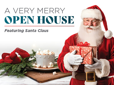 Santa Claus holds a wrapped gift and smiles beside a cup of hot chocolate with marshmallows and a plate of cookies. Text reads: “A Very Merry Open House Featuring Santa Claus.” Festive decorations are in the background.