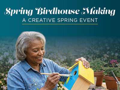 An older woman smiles while painting a yellow and blue birdhouse outdoors, surrounded by potted plants. Text reads: “Spring Birdhouse Making—A Creative Spring Event.”.