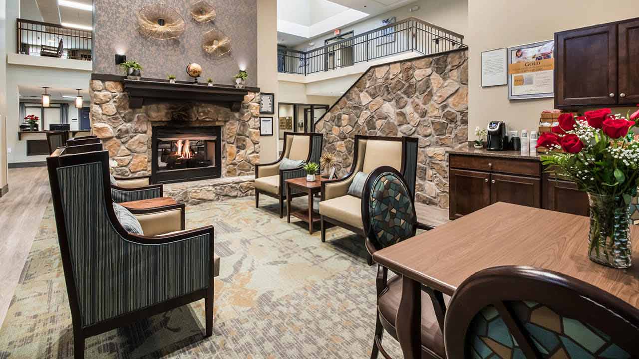 A room with a stone fireplace and chairs.