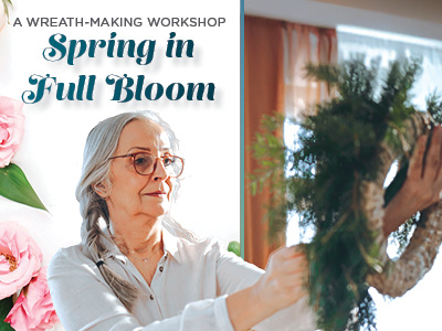 Older woman with gray hair and glasses arranges greenery on a wreath indoors. Text reads “A Wreath-Making Workshop, Spring in Full Bloom.” Pink flowers are visible on the left side of the image.