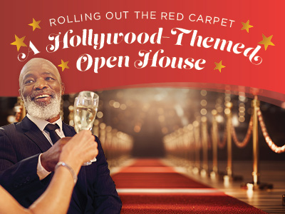 A smiling man in a suit holds a champagne glass at a glamorous event with a red carpet and golden stanchions. Text reads: “Rolling Out the Red Carpet: A Hollywood-Themed Open House.”.