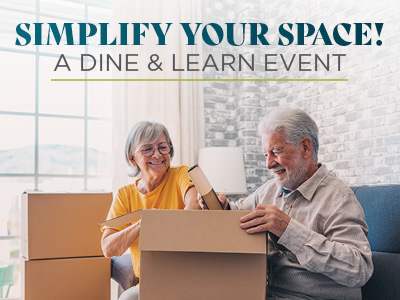 An older couple sits on a couch, smiling as they pack items into cardboard boxes. Text above them reads, “SIMPLIFY YOUR SPACE! A DINE & LEARN EVENT.” Bright window and brick wall in the background.