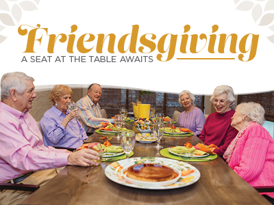 Six senior adults seated around a dining table set for a meal, with text overlay reading “Friendsgiving: A seat at the table awaits.”